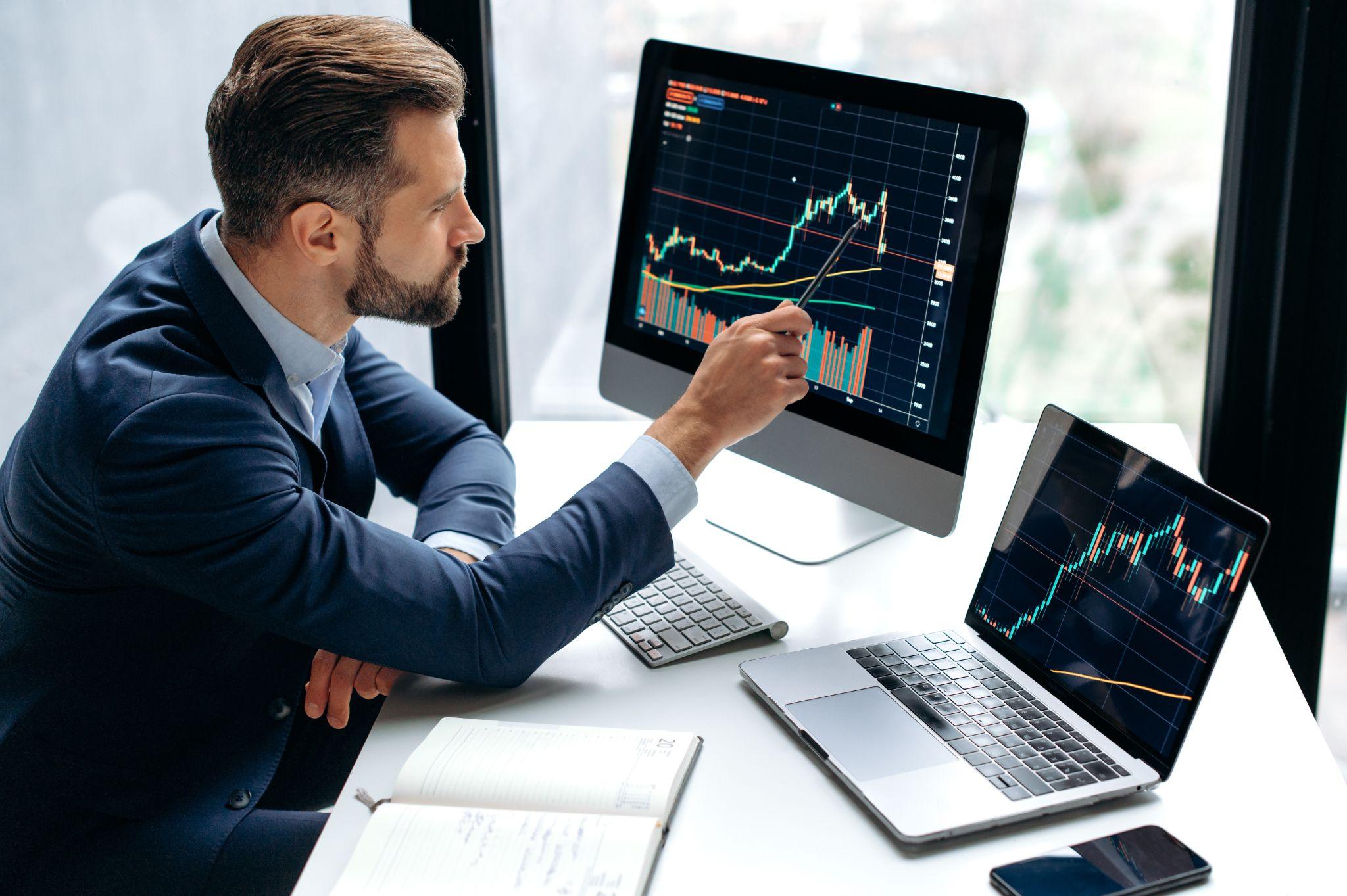 Businesswoman studies financial market risks and profits, calculating money with statistics graphs on computer screen