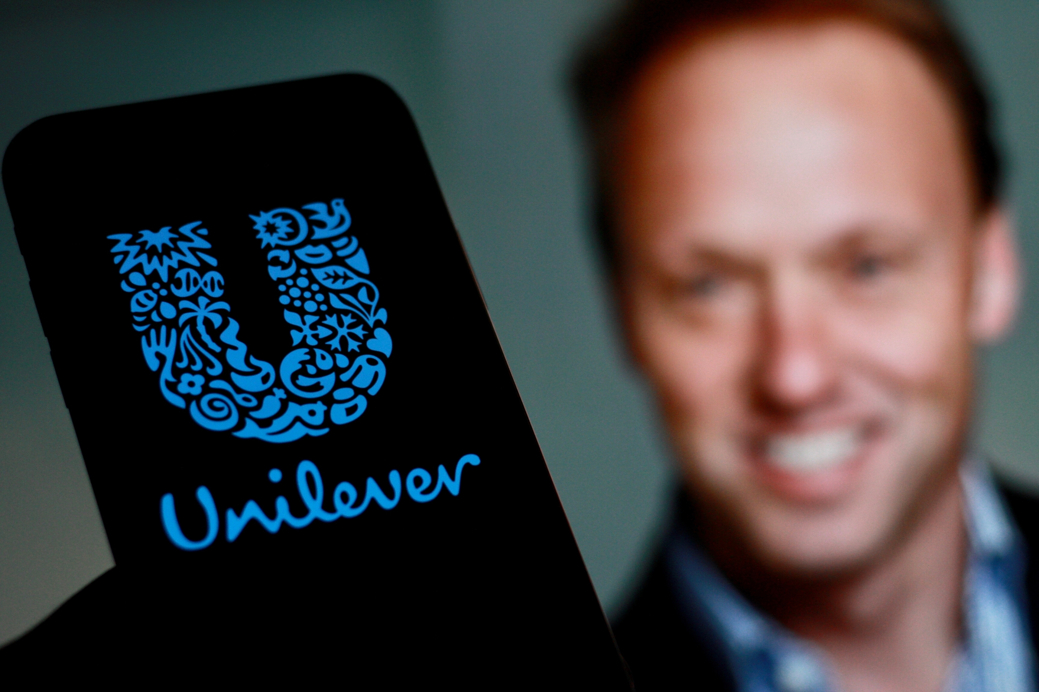 The logo of Unilever, a multinational company headquartered in London, with CEO Hein Schumacher in the background.