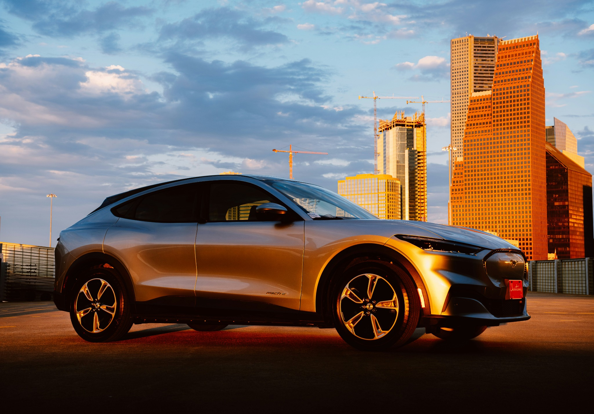 Ford electric vehicle in an urban setting during sunset, with skyscrapers in the background, highlighting the modern design