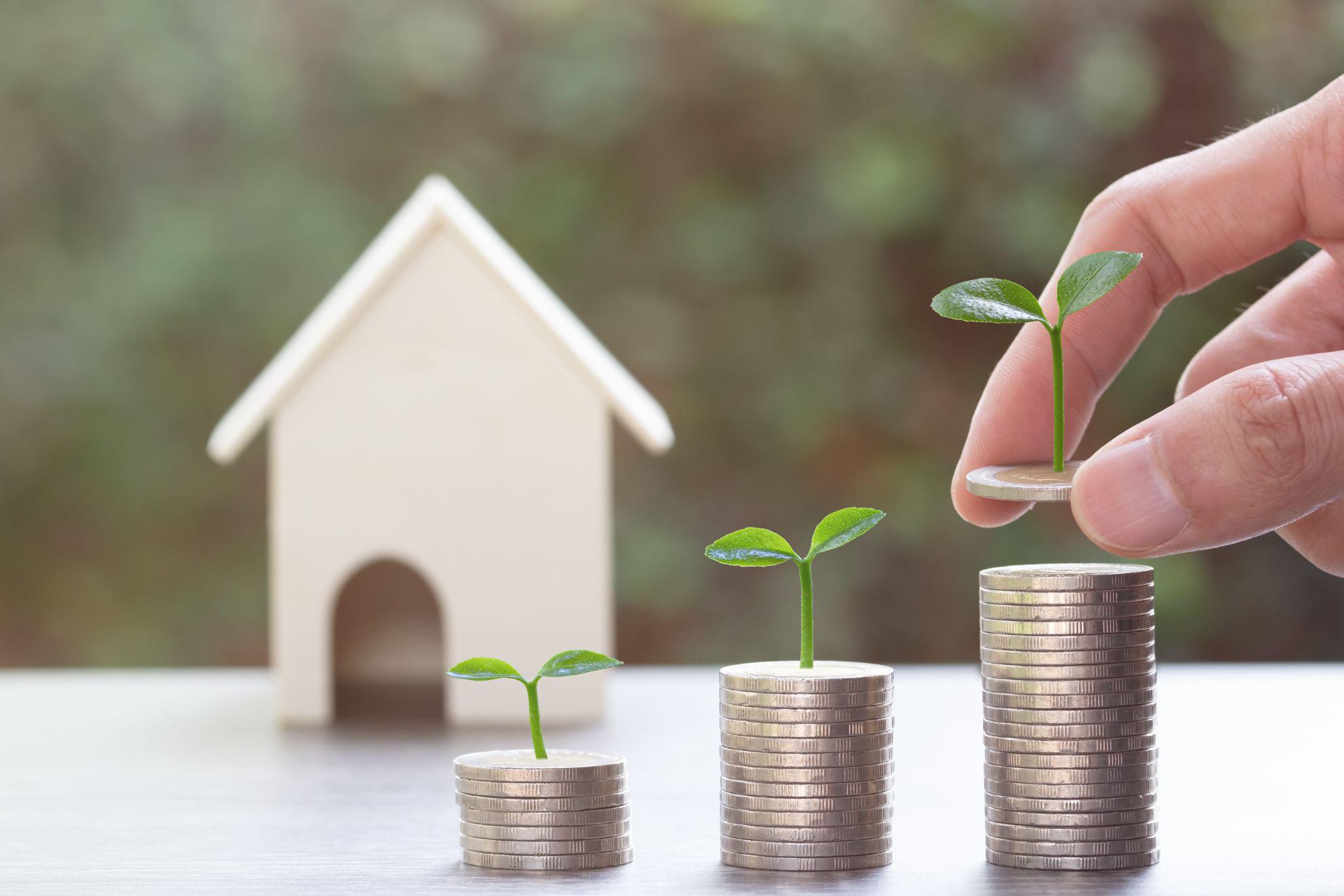 Agents offer housing contracts. Businessman holds small house model with property insurance at home sales office table.