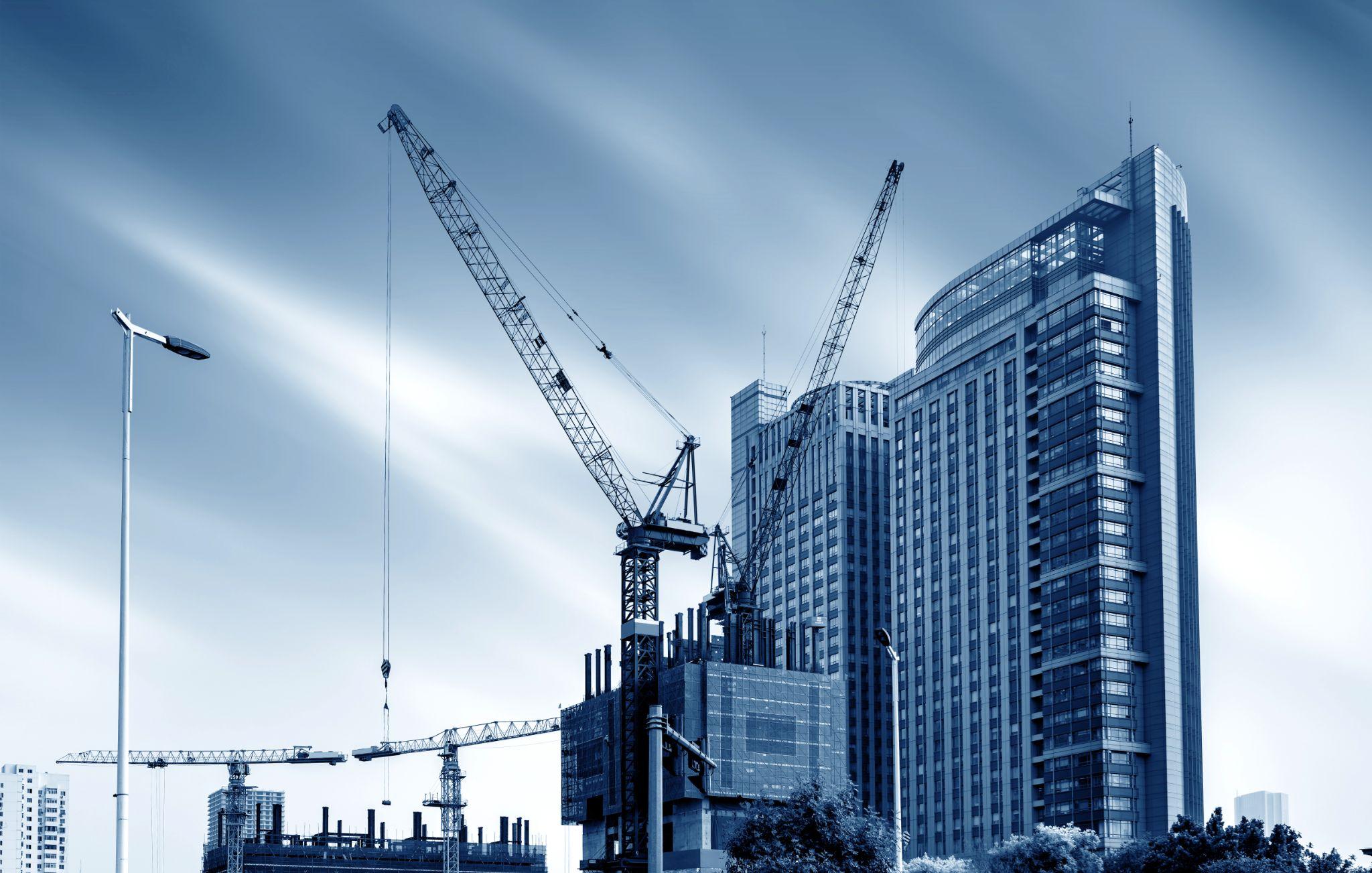 Building construction site, tall skyscrapers and cranes.